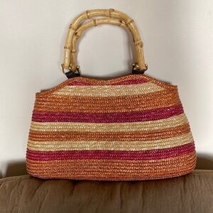 Gorgeous straw purse w/ bamboo handles. Snap closure and several inner pockets